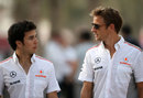 Jenson Button and Sergio Perez walk through the paddock