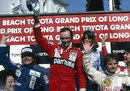 Niki Lauda celebrates his victory on the podium alongside Keke Rosberg and Gilles Villeneuve