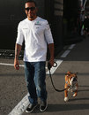 Lewis Hamilton takes his dog, Roscoe, for a walk in the paddock