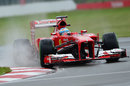 Fernando Alonso splashes through the puddles at turn two