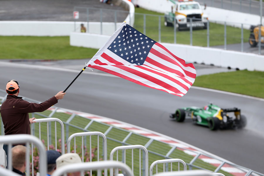 Alexander Rossi passes an American flag during FP1