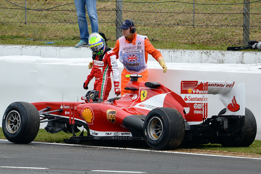 Felipe Massa inspects his damaged Ferrari after another crash