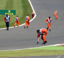 Marshals clear rubber from the track after another blowout