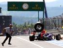 A loose wheel from Mark Webber's car bounces down the pit lane after hitting a cameraman