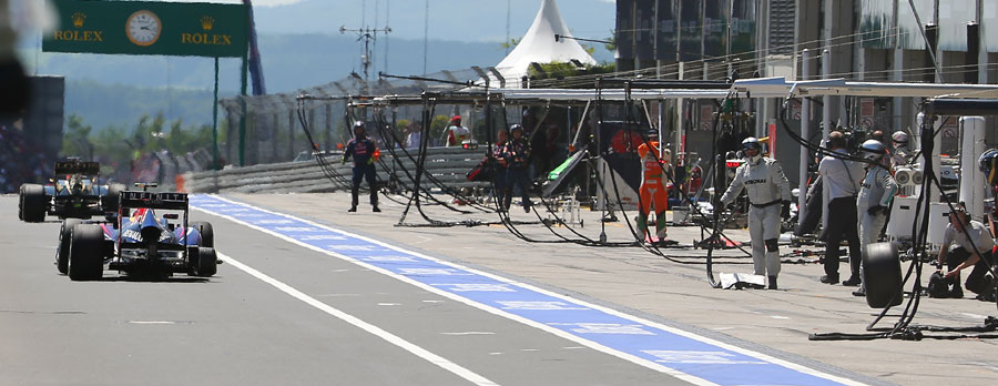 A loose wheel from Mark Webber's car bounces down the pit lane towards cameraman Paul Allen
