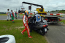 Fernando Alonso hitches a ride back to the pits as his stricken Ferrari is recovered