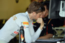 Romain Grosjean studies data in the Lotus garage