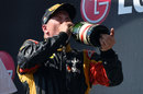 A soaked Kimi Raikkonen takes a swig of champagne