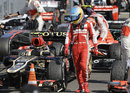 Fernando Alonso inspects Romain Grosjean's Lotus as he walks through parc ferme
