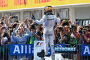 Lewis Hamilton celebrates victory on top of his car