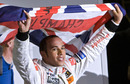 Lewis Hamilton waves his national flag to celebrate after winning the F1 World Championship