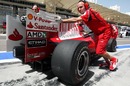 Ferrari mechanics take Felipe Massa's car back to the pits