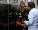 Kimi Raikkonen chats with his manager Steve Robertson behind the Lotus motorhome
