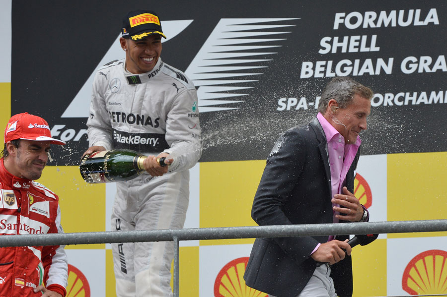 Lewis Hamilton sprays podium interviewer David Coulthard with champagne
