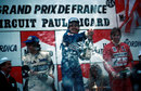 Alain Prost celebrates his victory on the podium alongside Nelson Piquet and Eddie Cheever