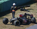Kimi Raikkonen walks away from his heavily-damaged Lotus after crashing at the end of FP1