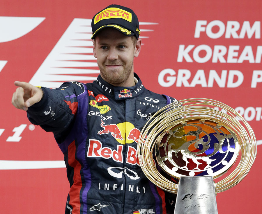 Sebastian Vettel salutes his team on the podium