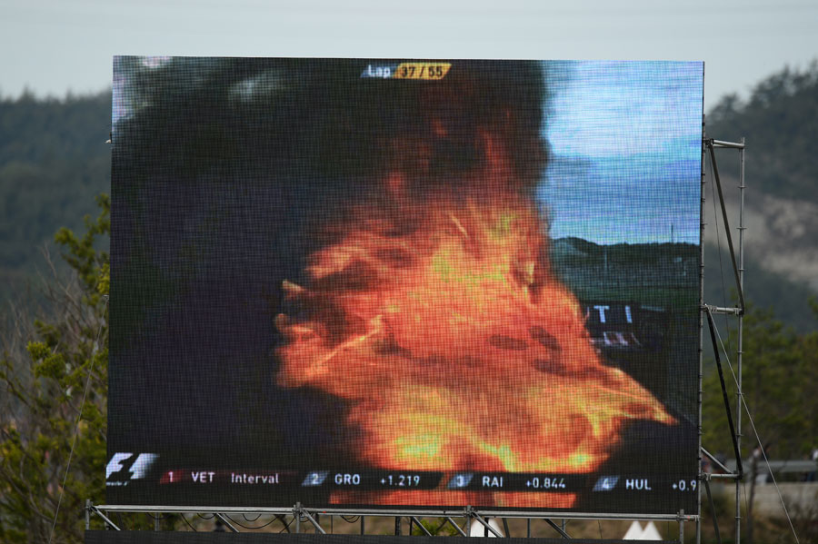Mark Webber's Red Bull burns after being hit by Adrian Sutil