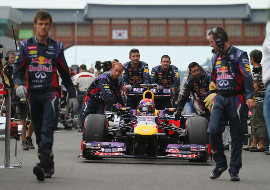 Sebastian Vettel is wheeled up the grid by his Red Bull team