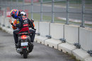 Mark Webber gestures as he gets a lift back to the paddock