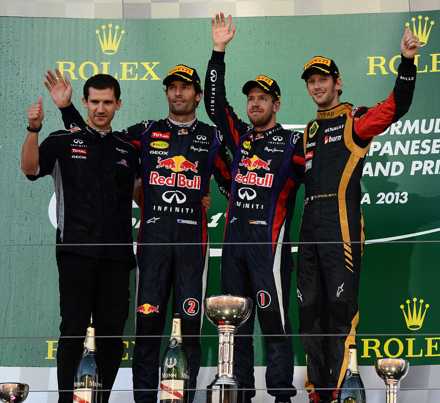 The top three salute the crowd on the podium