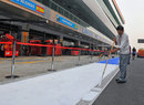 A track worker adds the finishing touches to the pit lane