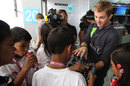 Nico Rosberg shows his steering wheel to young fans in the Mercedes garage