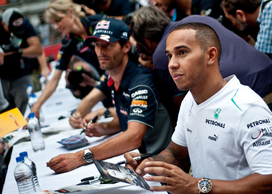 Lewis Hamilton alongside Mark Webber at the driver autograph session