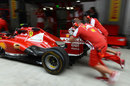 Ferrari mechanics push the car in to the pit box during pit stop practice