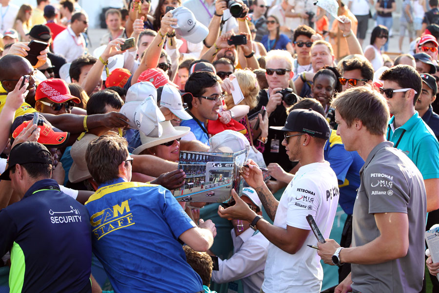Lewis Hamilton signs autographs in the pit lane