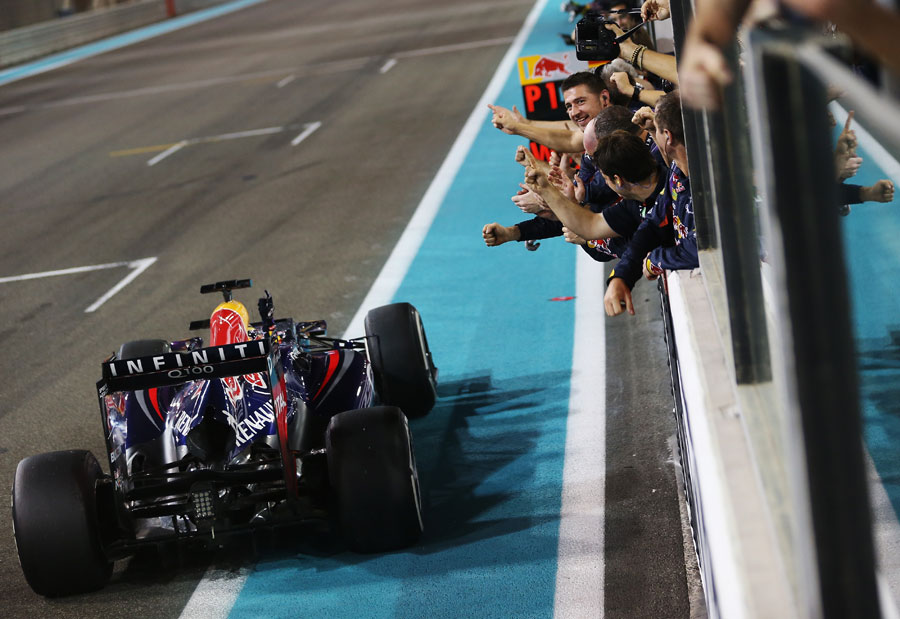 Sebastian Vettel celebrates as he crosses the line with his Red Bull team