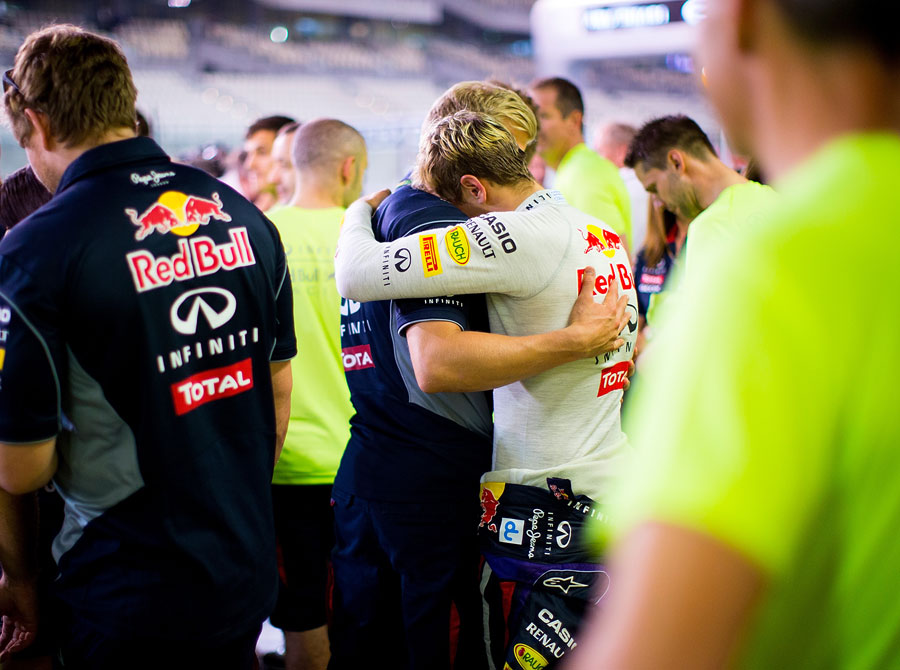 An emotional Sebastian Vettel embraces his trainer Heikki Huovinen in the paddock