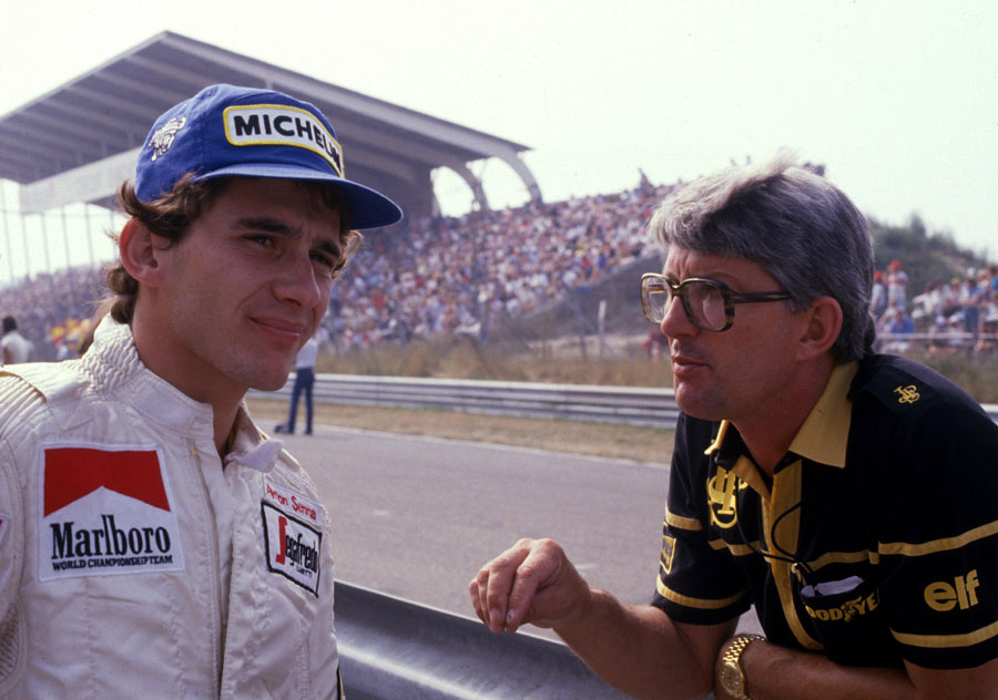 Ayrton Senna talks to Lotus team manager Peter Warr on the pit wall