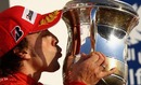 Fernando Alonso kisses a trophy