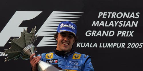 Race winner Fernando Alonso receives the trophy on the podium