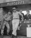 Juan Manuel Fangio talking to Mercedes team member Karl Kling