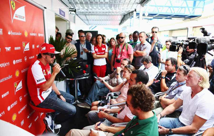 Fernando Alonso faces the press in the paddock