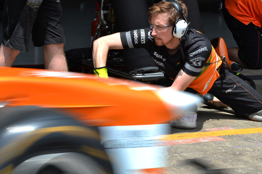 A mechanic focuses during a Force India pit stop