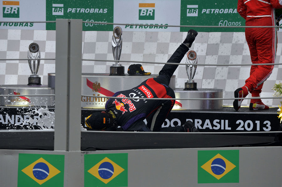 Mark Webber falls over on the podium celebrating second place in his final race
