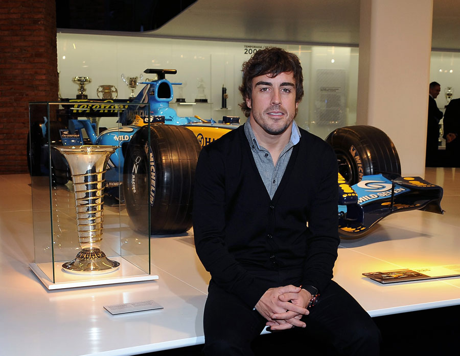 Fernando Alonso poses with his championship-winning Renault RS26 at his museum opening