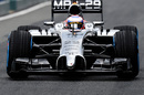 Jenson Button takes the McLaren through a drying track 