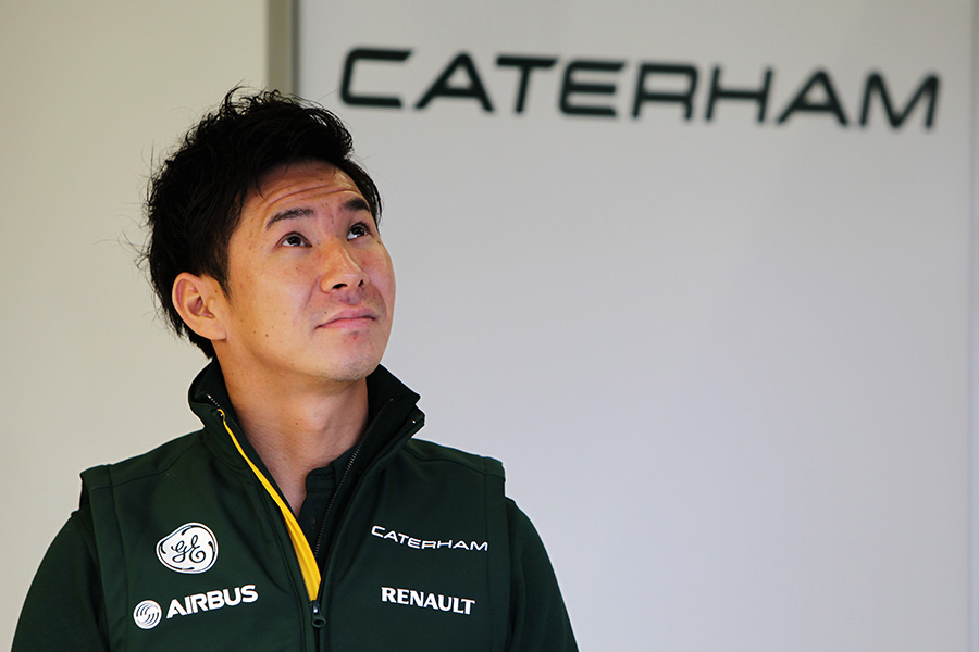 Kamui Kobayashi checks the timing screens in the garage