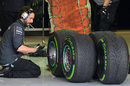 A Mercedes employee inspects the Pirelli tyres
