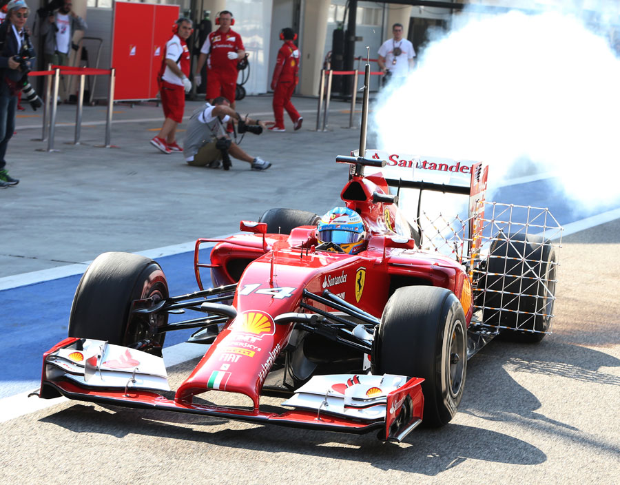 Fernando Alonso leaves the garage in a cloud of smoke