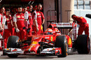 Ferrari mechanics watch on as Kimi Raikkonen leaves the pit box
