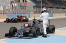 Pastor Maldonado passes a stricken Jenson Button after the McLaren came to a halt on the back straight