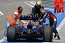 Sebastian Vettel helps push his Red Bull back to the pits