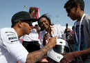 Lewis Hamilton signs an autograph for a young fan