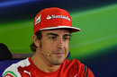 Fernando Alonso listens to a question from the media