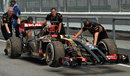 Romain Grosjean's Lotus E22 is brought back to the pit lane in FP2